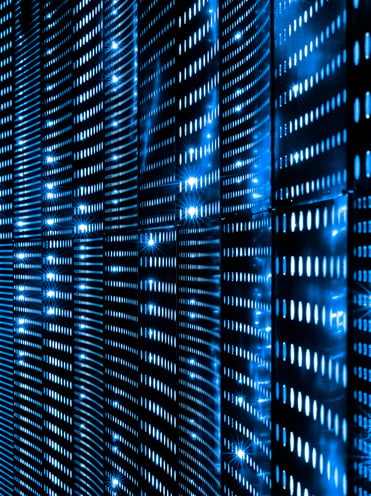 Close-up of perforated server rack panels glowing with rows of blue light against a dark background
